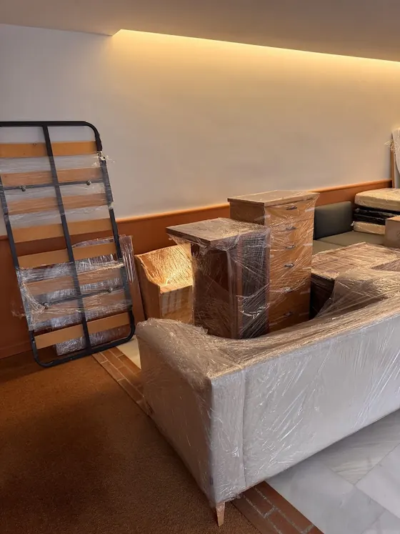 Sofá y muebles protegidos con film antes de una mudanza